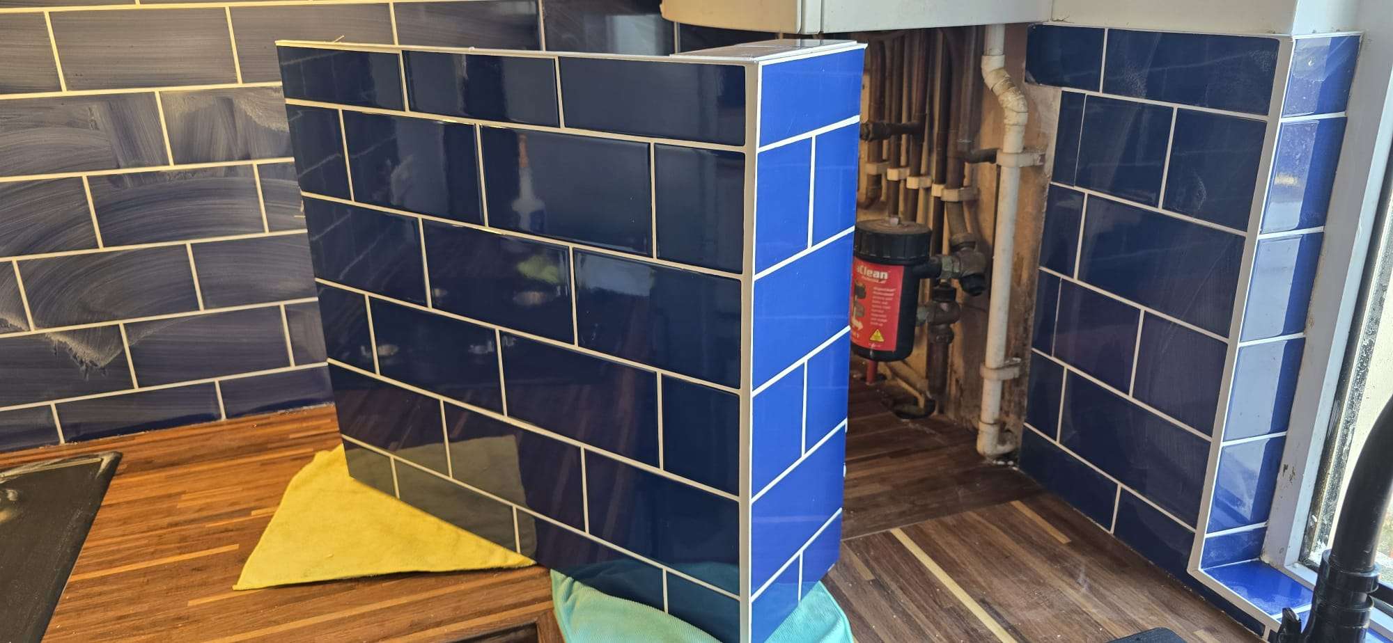Custom moisture- and heat-resistant box built to cover under-boiler pipework, shown before installation